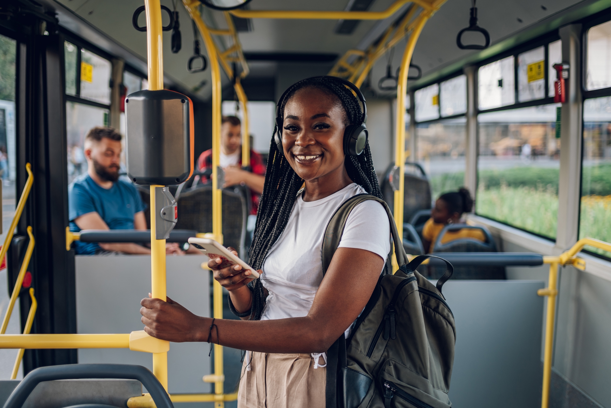 A woman smiling on a bus with others in the background